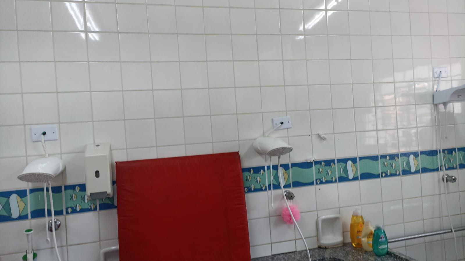 Visão do banheiro da creche com os chuveiros atendidos.