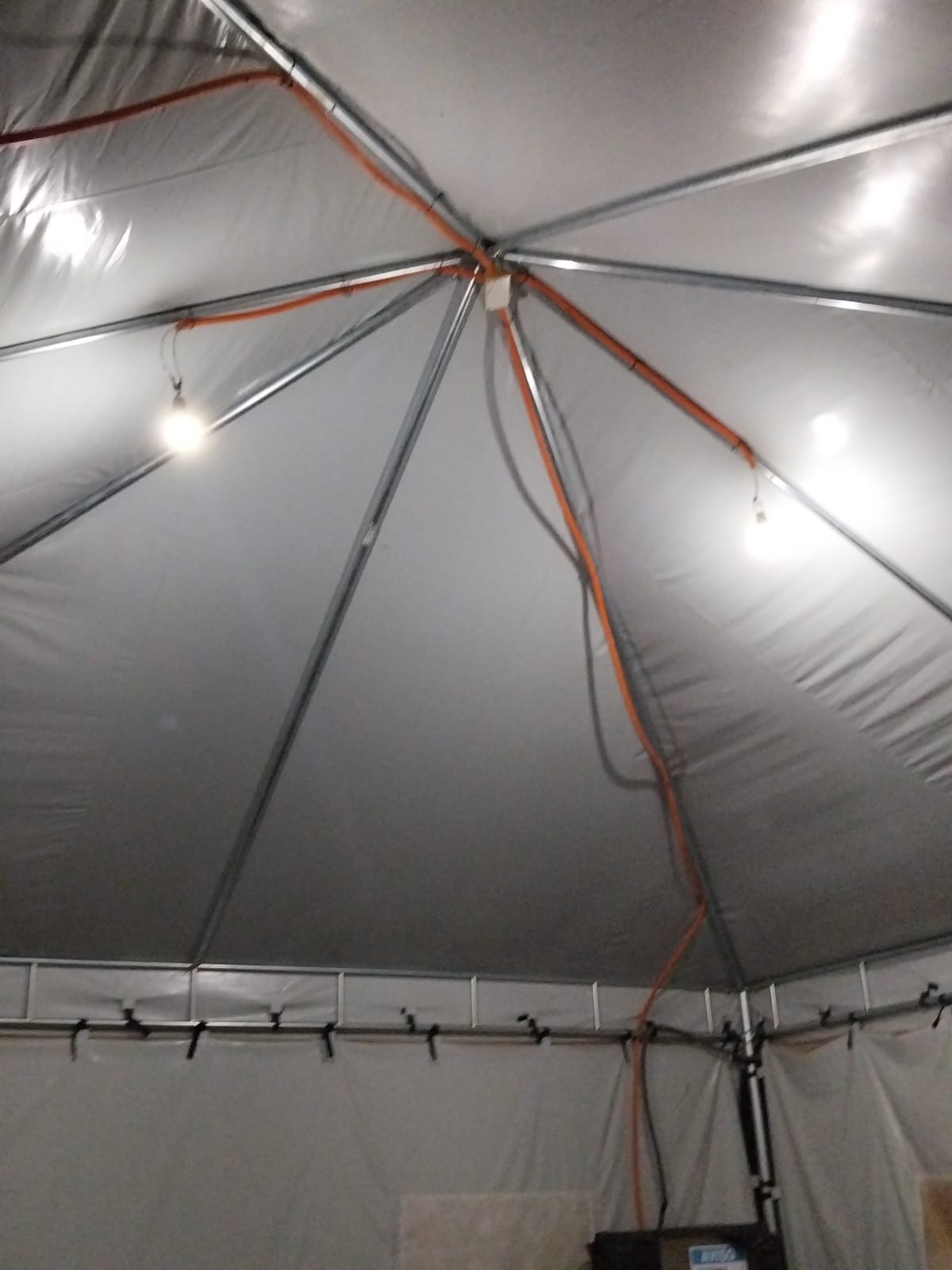 Iluminação ligada no interior da estrutura de tenda.