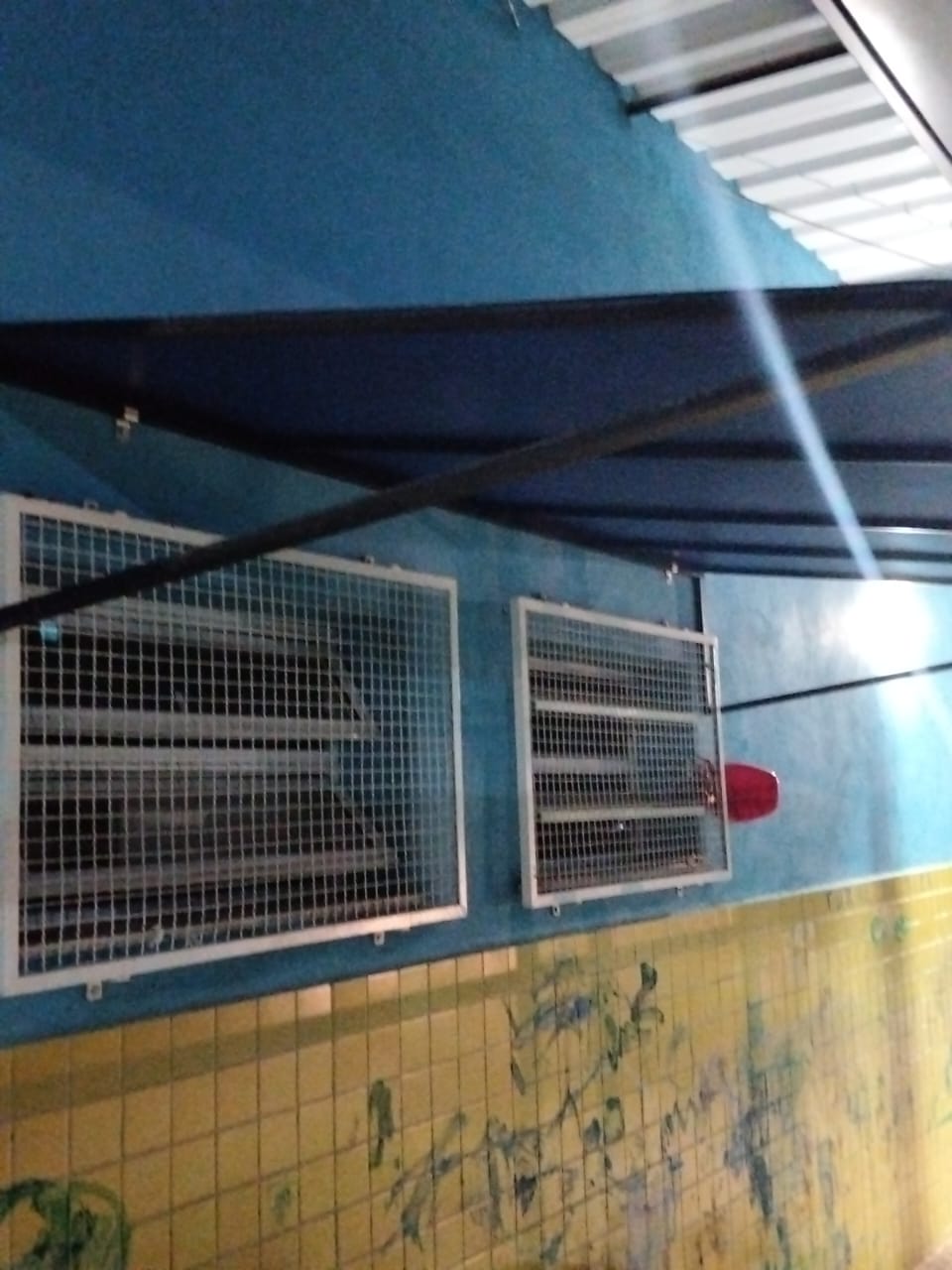 Toldo e grades de proteção nas janelas da fachada.