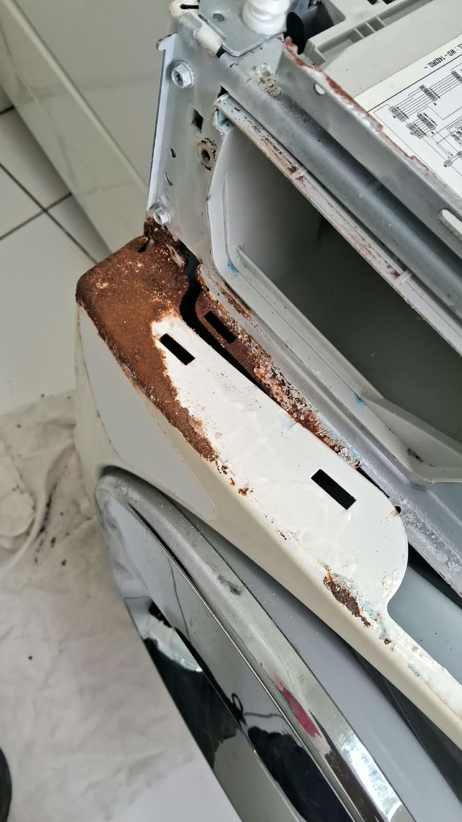 Parte superior aberta da lavadora, com acesso aos componentes.